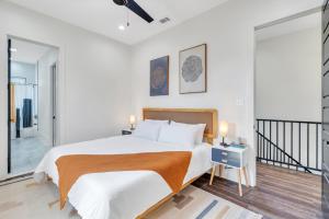 a white bedroom with a large bed and a balcony at Modern Mid-city Maison in New Orleans