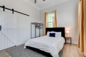 um quarto branco com uma cama e uma janela em Revived Nola Home Near Everything! em Nova Orleans