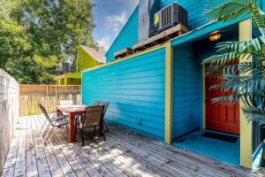 uma casa azul com uma mesa e cadeiras num deque em Revived Nola Home Near Everything! em Nova Orleans