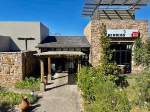 a brick building with a sign for a restaurant at Hilltop 39, Oubaai Golf Estate in Herolds Bay