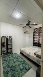 una camera con letto e ventilatore a soffitto di Homestay D'Putra Bertam a Kepala Batas