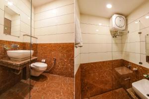 a bathroom with a toilet and a glass shower at FabHotel Rosewood Inn GT Road Near Amritsar Railway Station in Amritsar