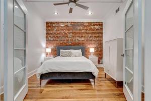 um quarto com uma cama e uma parede de tijolos em Carnival Condo em Nova Orleans