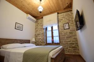 a bedroom with a bed and a brick wall at 4 Rooms Gjirokastra in Gjirokastër