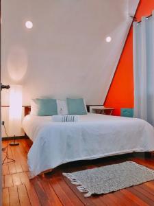 1 dormitorio con 1 cama con pared de color naranja y blanco en Molinillo Vacation Cabin, 