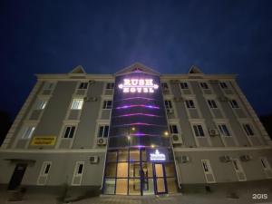 a building with a purple lit up sign on it at Rush Hotel in Atyrau