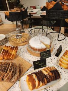 - une table garnie de différents types de pain et de viennoiseries dans l'établissement Hôtel Restaurant BO & MIA, à La Baule