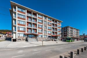 an apartment building on a city street with a street at HCG Panorama Villa Deluxe Apartment in Bakuriani