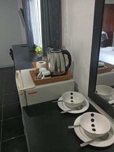 a counter with plates and a tea kettle on it at Krabi Nemo House in Ao Nang Beach