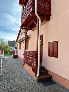 a building with a balcony and stairs on it at Andrea Apartman in Bük