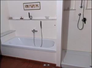盧卡的住宿－a casa di antonio，浴室设有带淋浴的白色浴缸。