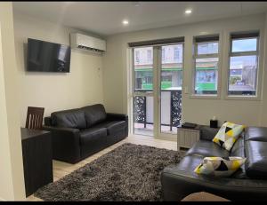 a living room with a couch and a flat screen tv at The Runaway in Dargaville