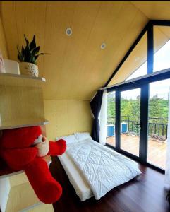 un osito de peluche rojo sentado en un estante en un dormitorio en Mộc Hoa Viên, en Ấp Thiện Lập