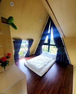 een slaapkamer met een bed in een kamer met een raam bij Mộc Hoa Viên in Ấp Thiện Lập