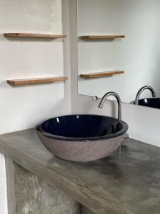 a bathroom with a large bowl sink on a counter at Sepeda Hostel in Canggu