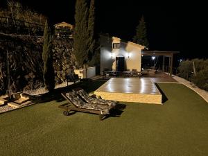 La Casita de mama في فيليز-مالاغا: حديقة خلفية في الليل مع مقعد ومنزل