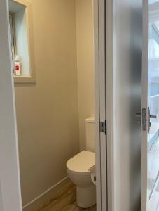 a small bathroom with a toilet and a mirror at The Runaway in Dargaville