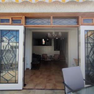 eine offene Glastür in ein Wohnzimmer mit einem Tisch in der Unterkunft QUIET DUPLEX CLOSE to the BEACH in Playa de las Americas