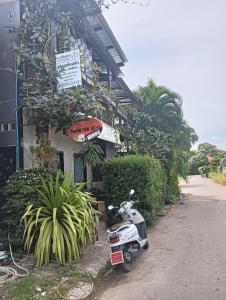 ein Motorroller, der außerhalb eines Gebäudes mit Pflanzen parkt in der Unterkunft Krabi Nemo House in Ao Nang Beach