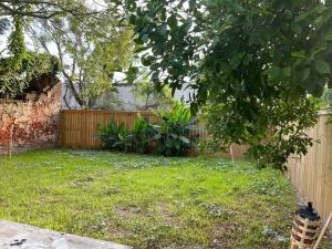 a backyard with a fence and a yard with green grass at Jazzed On Jackson in New Orleans