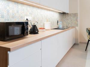 a kitchen with a counter with a microwave and a sink at Apartament Morski Wiatr in Ustronie Morskie