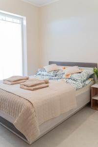 1 dormitorio con 1 cama grande y toallas. en Apartament Morski Wiatr, en Ustronie Morskie