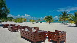 a row of benches on a beach with palm trees at The Secret Garden Koh Rong in Koh Rong Island
