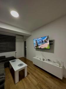 ein Wohnzimmer mit einem Sofa und einem TV an der Wand in der Unterkunft Apartment Chloee in Gevgelija