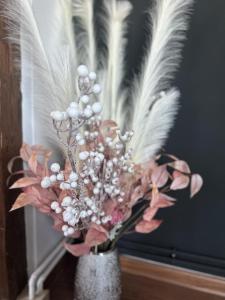 a vase with feathers and pink flowers in it at Central Station Apartment in Cluj-Napoca
