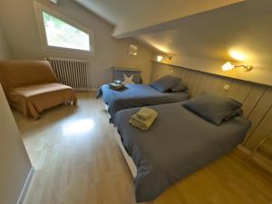 um quarto com 2 camas, uma cadeira e uma janela em Gîte classé 3* dans magnifique bastide provençale em Auriol