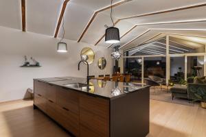 a kitchen with a sink and a living room at Enter Tromsø Luxury Villa in Tromsø