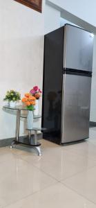 a stainless steel refrigerator sitting next to a table with flowers at Eniter Two Bedrooms Luxry Apartment in Karachi