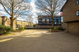 a brick parking lot with trees in front of a building at Larger Groups Excel Canary Wharf Apartments with Parking in London