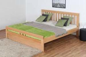 una cama de madera con almohadas verdes en una habitación en Appart Suites Citadines Access 15 minutes Paris Montparnasse - Metro & Accès facile Paris Parc Expo, en Châtillon