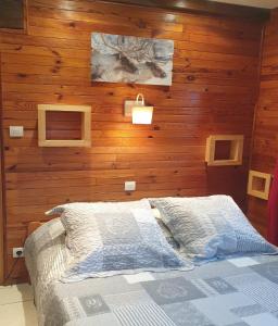 - une chambre avec un mur en bois et un lit dans l'établissement Chalet le Grand Tétras, à La Bresse