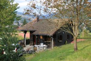 une maison noire sur une colline dans un champ dans l'établissement Chalet le Grand Tétras, à La Bresse