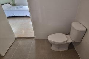 een badkamer met een toilet en een bed in een kamer bij Breezy Pattaya in Jomtien Beach