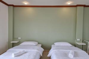 2 bedden in een kamer met witte lakens bij Breezy Pattaya in Jomtien Beach