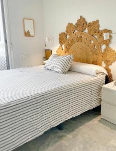 a large bed in a bedroom with a large headboard at Marina Sunrise in La Herradura