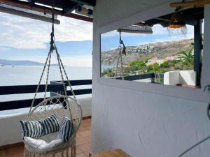 a porch with a swing and a view of the ocean at Marina Sunrise in La Herradura