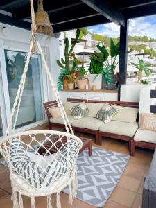 a porch with a swinging chair and a couch at Marina Sunrise in La Herradura