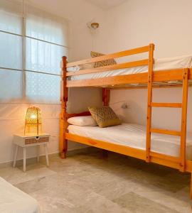 a bedroom with two bunk beds and a lamp at Marina Sunrise in La Herradura