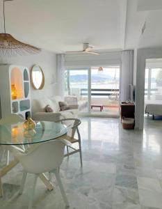 un soggiorno con tavolo in vetro e divano di Marina Sunrise a La Herradura