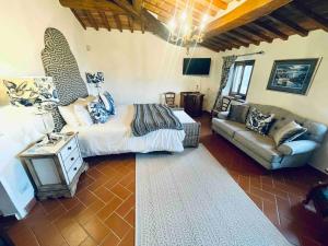 uma sala de estar com uma cama e um sofá em Pevoni - 1 Bed aprtment with stunning Tuscan views em Anghiari