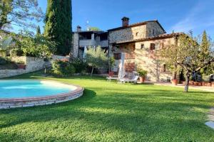 uma antiga casa de pedra com uma piscina num quintal em Pevoni - 1 Bed aprtment with stunning Tuscan views em Anghiari