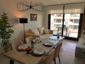 un soggiorno con un tavolo e un divano di Luxe Appartement Orihuela Costa - Villamartin -Aire Residencial - green and pool view a Orihuela Costa