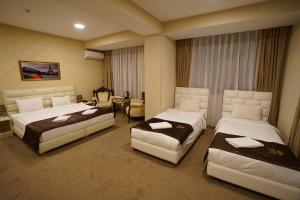 Cette chambre comprend 2 lits et une table. dans l'établissement Shahdag Quba & Truskavets, à Quba