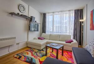 ein Wohnzimmer mit einem Sofa und einem Tisch in der Unterkunft Lovely apartment in Aspen Golf Resort with SPA in Bansko