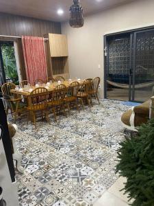Lọ Lem Homestay في فينه لونج: غرفة طعام مع طاولة وكراسي على أرضية من البلاط