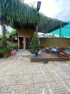 ein Gebäude mit einer Terrasse mit Bäumen und Pflanzen in der Unterkunft Lọ Lem Homestay in Vĩnh Long